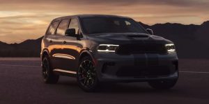 A dark-colored 2023 Dodge Durango parked on an open road at sunset